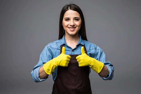 Cleaner woman thumbs up with yellow gloves on the grey background