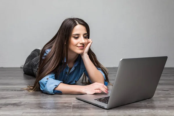 Mujer sonriente trabajando en el portátil en el suelo — Foto de Stock