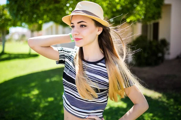 Jovem atraente desfrutando de seu tempo fora no parque no fundo verde . — Fotografia de Stock