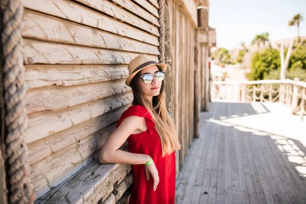 Beau modèle féminin dans une robe rouge et chapeau sur la station estivale. vocation estivale . — Photo