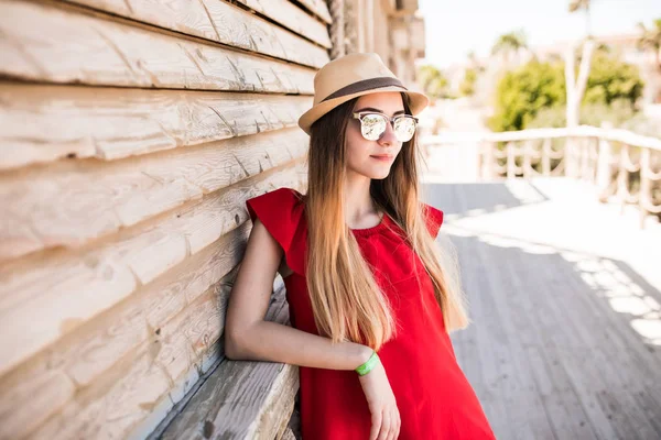 빨간 드레스와 모자와 선글라스에 여름 리조트에서 아름 다운 여성 모델. 여름 직업. — 스톡 사진