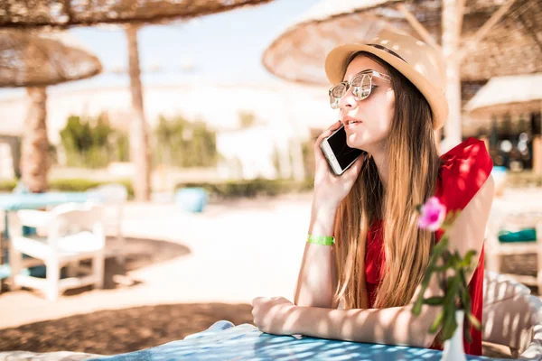 Νεαρή γυναίκα που περιμένει για παραγγελία και μιλάει στο τηλέφωνο με το εστιατόριο κοντά στη θάλασσα. Καλοκαιρινές διακοπές — Φωτογραφία Αρχείου