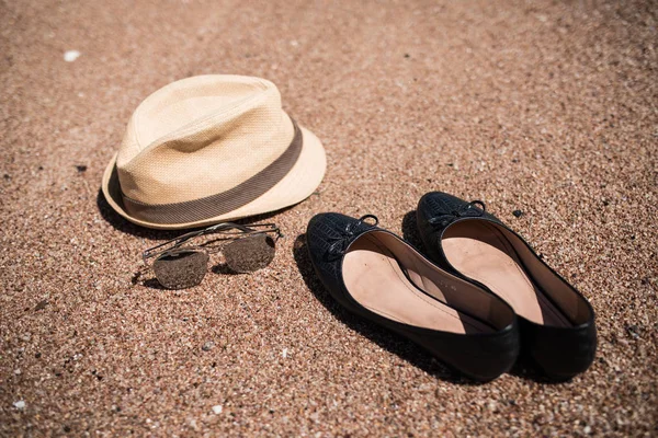 Καλοκαιρινό καπέλο, παπούτσια και γυαλιά ηλίου στην άμμο της θάλασσας. Καλοκαιρινές διακοπές — Φωτογραφία Αρχείου