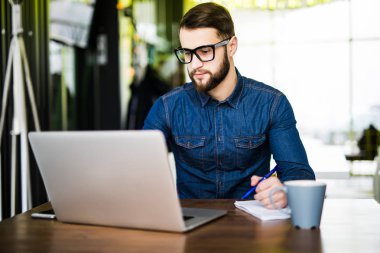 Öğrenci meşgul Not yeni dizüstü bilgisayarından süre browsing belgili tanımlık enterne ile sabah kahvesini almak