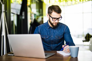 Öğrenci meşgul Not yeni dizüstü bilgisayarından süre browsing belgili tanımlık enterne ile sabah kahvesini almak