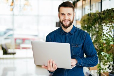 El ofis içinde laptop ile gülümseyen akıllı adam