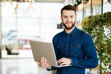 El ofis içinde laptop ile gülümseyen akıllı adam