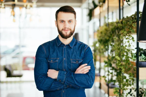 Mutlu yakışıklı genç modern ofis çapraz elleriyle portresi — Stok fotoğraf