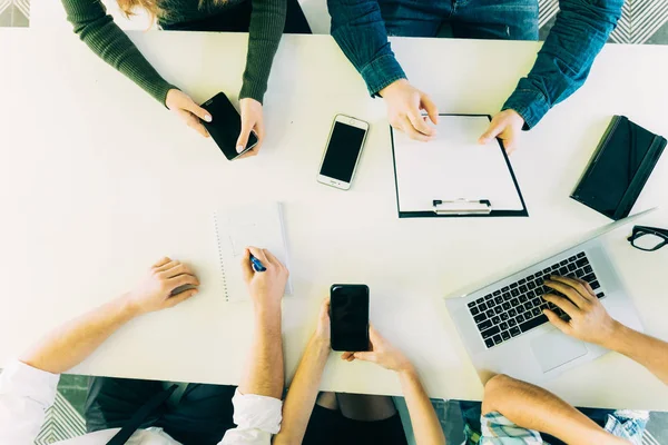 Menselijke handen op tafel met mobiliteit apparaten bekijken van bovenaf — Stockfoto