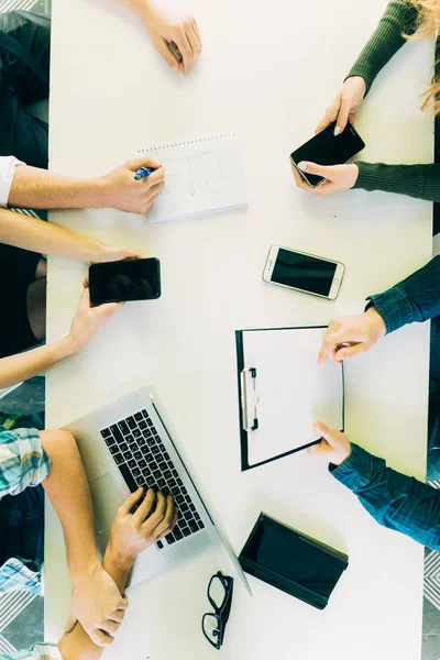 Menselijke handen op tafel met mobiliteit apparaten bekijken van bovenaf — Stockfoto