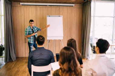 Fikir oluşturma. Genç yakışıklı proje yöneticisi bir yaratıcı ekip toplantısı onun arkadaşları ekip çalışması kavramı ile beyin fırtınası flipchart çizim office önde gelen