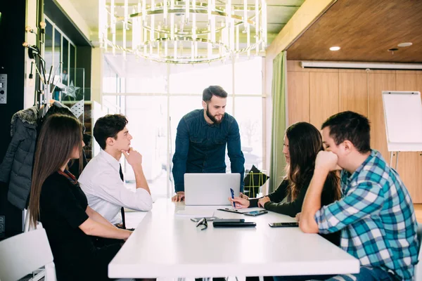 Jonge freelance teamvergadering aan tafel bespreken van doelen in het moderne kantoor — Stockfoto