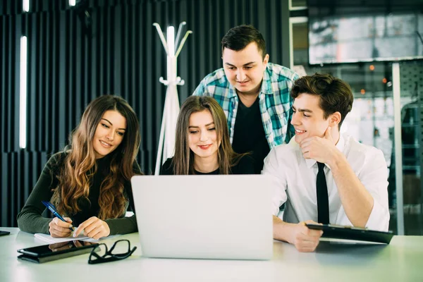 Portrett av en gruppe forretningsfolk som arbeider sammen på et møte over en bærbar datamaskin – stockfoto