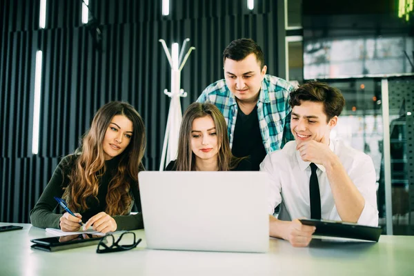 Jonge freelancer over laptop tijdens bijeenkomst in moderne kantoren — Stockfoto