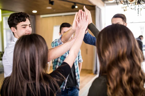 Jonge groep van mensen hoge fiving elkaar op vergadering of seminat van teamwork in kantoor — Stockfoto