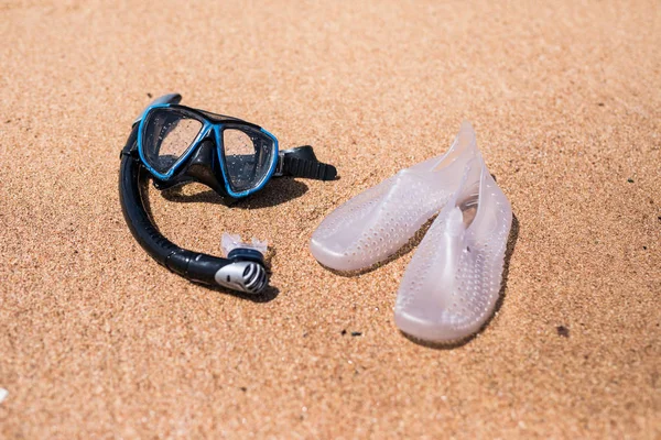 Fondo de vacaciones. Máscara de buceo y chanclas en la playa del océano — Foto de Stock