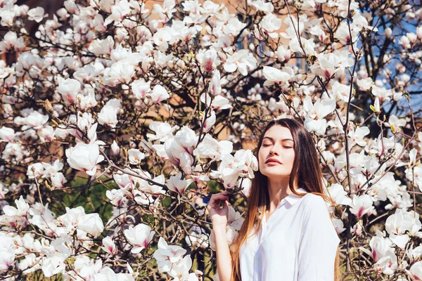 Ritratto di donna vicino a un bellissimo albero di magnolie rosa in fiore nella stagione primaverile — Foto Stock