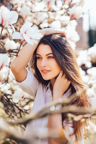 Jeune jolie fille se détendre dans un beau jardin de magnolias roses fleurissant sur la saison printanière — Photo
