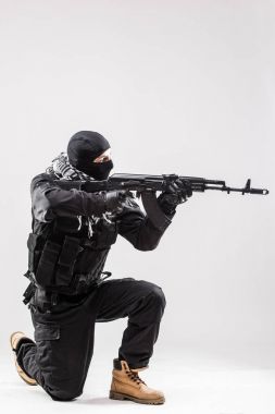 Terrorist holding a machine gun in his hands aim isolated over white clipart