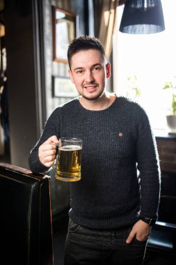 adam bir barda veya kupa bira şerefe için havadaki yüksek tutarak bar