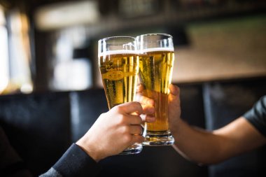 Şerefe. İki adamın barda bira ile toasting gömlek yakın çekim sayaç