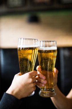 Şerefe. İki adamın barda bira ile toasting gömlek yakın çekim sayaç