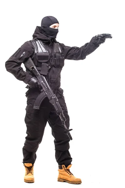 Retrato de bandido perigoso em preto vestindo balaclava e segurando arma mostrar sinal na mão — Fotografia de Stock