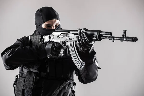 特殊部隊兵士男は灰色の背景に機関銃を保持します。 — ストック写真