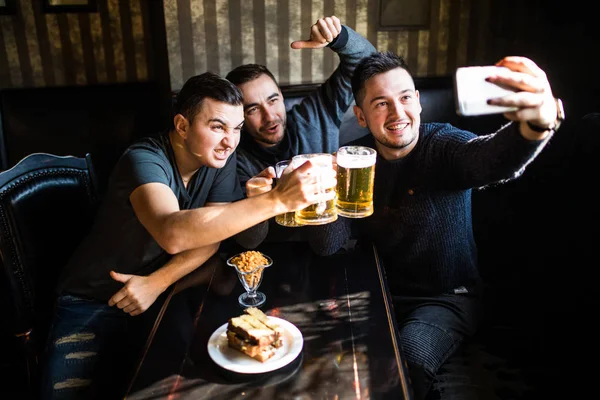 Gärna manliga vänner tar selfie och dricka öl på bar eller pub på part — Stockfoto