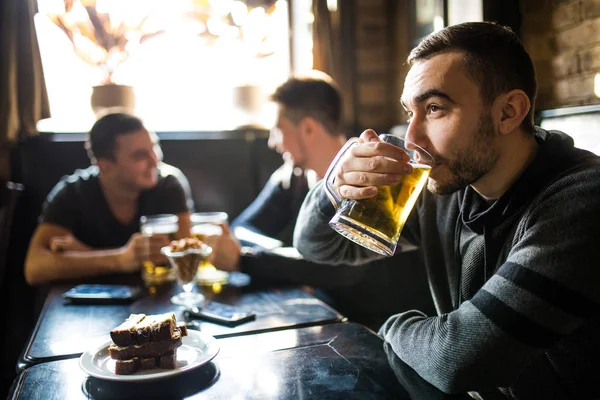 男ビールのパブで飲んで友達を議論します。パブで友達. — ストック写真