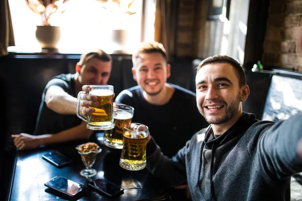 Gärna manliga vänner dricka öl och tar selfie med smartphone på bar eller pub — Stockfoto