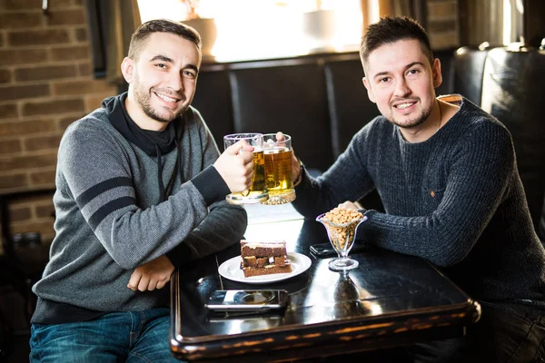 Dois amigos bonitos num bar com copos de cerveja. Hora dos amigos . — Fotografia de Stock