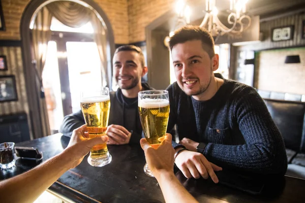 Två man i bar vid disken, bartendern att ge öl glas, vänner träffa killar i puben — Stockfoto