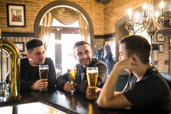 Velhos amigos alegres se divertindo e bebendo cerveja no balcão do bar no pub. Amigos se encontram — Fotografia de Stock