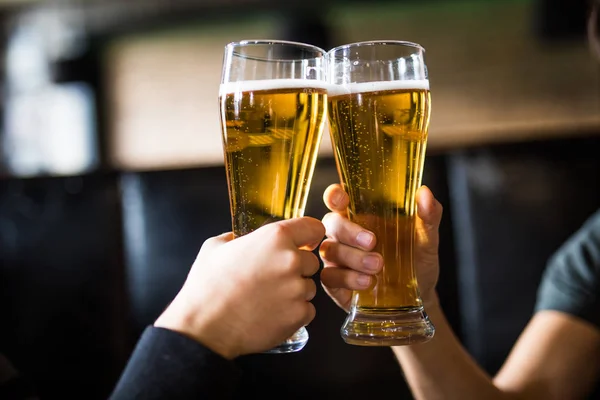 Homens saúdam com cerveja em copos no pub. Fechar . — Fotografia de Stock