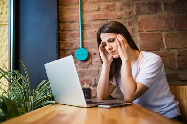 Mujer triste sosteniendo la computadora, pantalla de la tableta del ordenador portátil mirando sorprendida en la cafetería — Foto de Stock