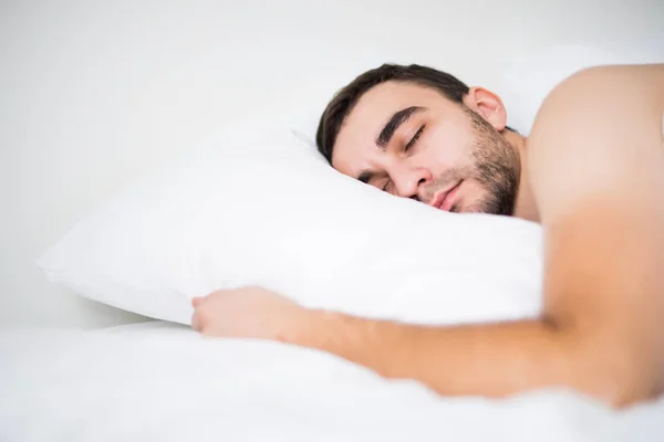 Спокойный мужчина спит в своей спальне дома — стоковое фото
