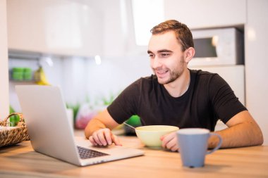 Adam kinchen kullanmak laptop süre içinde sabahları kahvaltı yemek