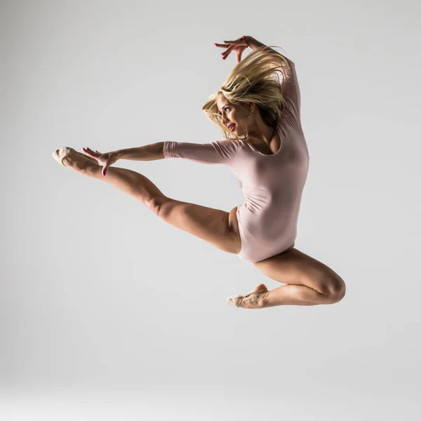 Mladá moderní gymnastiky baletku skákání na bílém pozadí — Stock fotografie