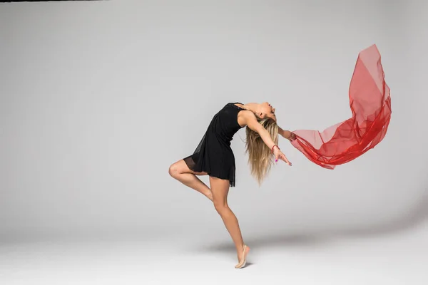 Γυμναστική χορευτής στην εργασία, ο χορευτής με κόκκινο μετάξι στον αέρα σε λευκό φόντο — Φωτογραφία Αρχείου