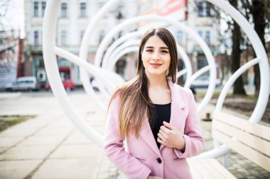 genç güzel kadın standind yakınındaki şehir sokak üzerinde pembe ceket sokakta modern tezgah