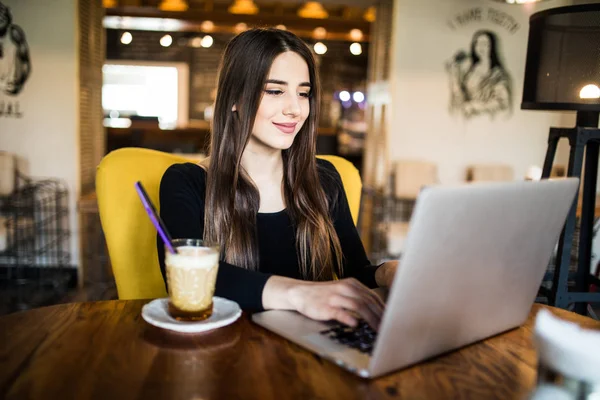 彼女はテキストからおいしいホット コーヒーのカップを飲むカフェでフリーランサーとして働く若い女の子の屋内ポートレート送信メール負荷写真 instagram フリーランサー — ストック写真