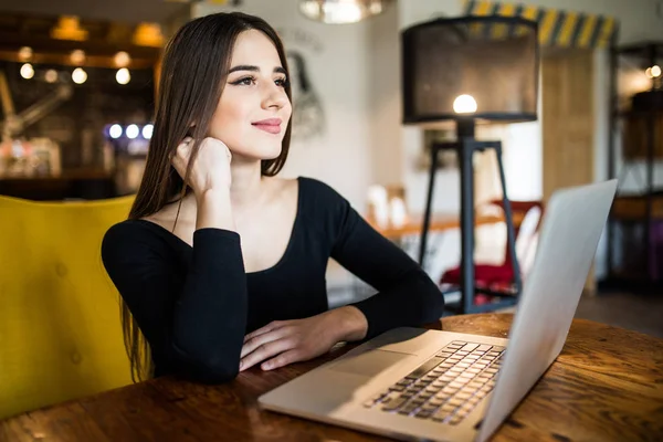 Hermosa mujer atractiva en el café con un ordenador portátil que tiene una pausa para el café — Foto de Stock