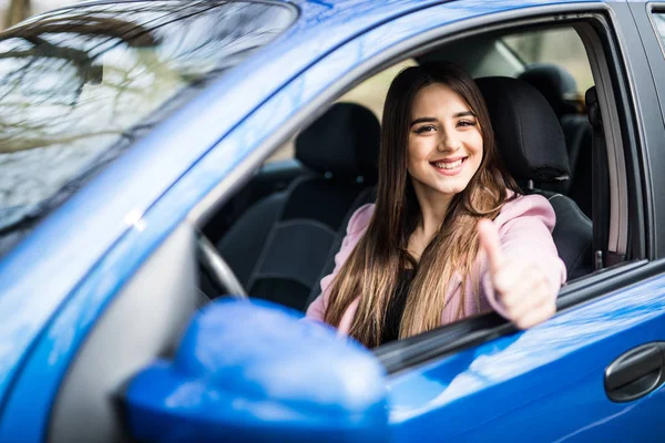 Feliz beleza jovem mulher está mostrando um polegar de um carro — Fotografia de Stock