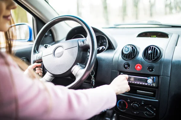 A mulher montou música no carro. Painel do carro. Fecho do rádio. Mulher prepara rádio — Fotografia de Stock