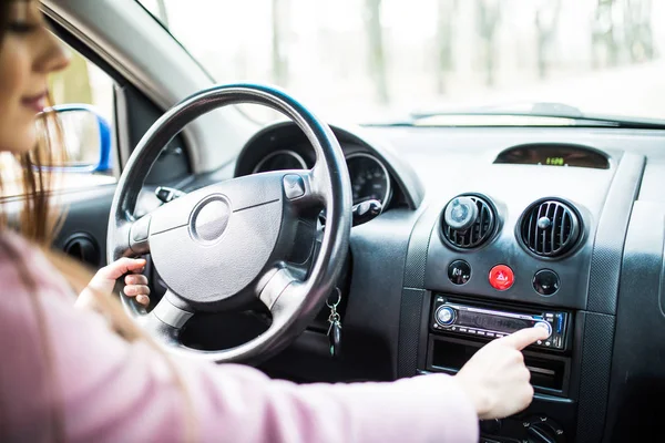 A mulher montou música no carro. Painel do carro. Fecho do rádio. Mulher prepara rádio — Fotografia de Stock