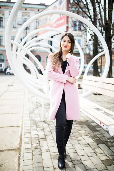 Genç güzel kadın standind yakınındaki şehir sokak üzerinde pembe ceket sokakta modern tezgah — Stok fotoğraf