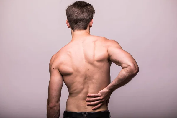 Mann reibt seinen schmerzhaften Rücken auf Grau. Schmerzlinderung, chiropraktisches Konzept — Stockfoto