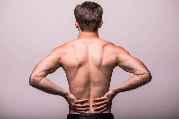 Nahaufnahme eines Mannes, der seinen schmerzhaften Rücken auf grauem Hintergrund reibt. — Stockfoto