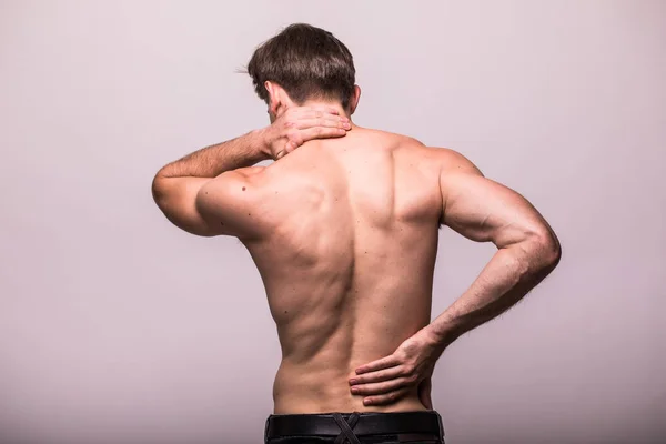 Nahaufnahme eines Mannes, der seinen schmerzhaften Rücken auf grauem Hintergrund reibt. — Stockfoto